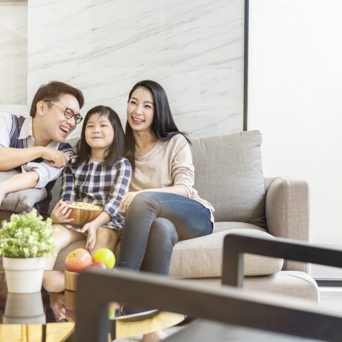 asian happiness Family talking and relaxing on sofa watch tv together